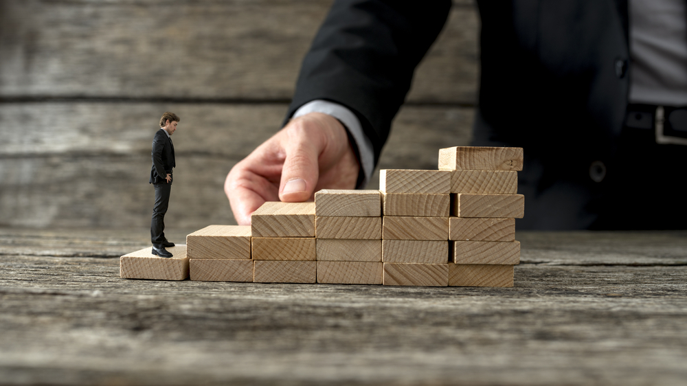 Demonstrating the process of setting up a company in Australia, a man climbs a staircase built step-by-step by another, representing the guidance provided by Boettcher Law's local director. This illustrates our commitment to crafting your successful business journey.