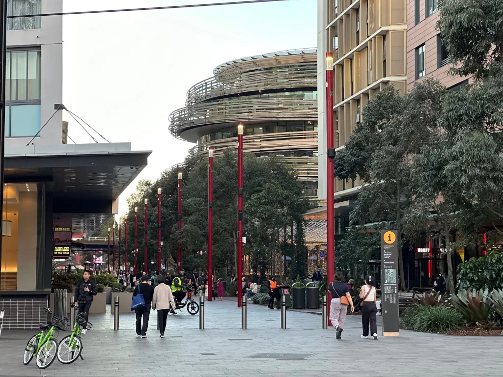 In this photo, people are walking down a lively pedestrian zone filled with restaurants and bars in Chinatown, Sydney. The scene captures the essence of why a knowledgeable commercial lease lawyer in Sydney is essential for securing prime business locations.